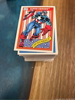 Stack of 1990 Impel Marvel Universe Series 1 Trading Cards showing Captain America card on top, cards appear in good condition.