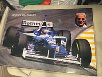 Full view of laminated print featuring Jacques Villeneuve driving a Williams Formula 1 car, with an inset headshot of Villeneuve.
