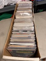 Long cardboard box filled with bagged comic books showing front and part of spines