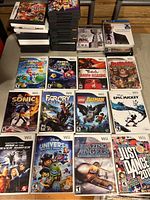 Several Wii game cases arranged side by side on a table with visible cover art for each title including Super Mario Galaxy 2 and LEGO Batman.