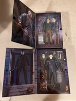Two Friday the 13th Jason Voorhees action figures displayed in original flap box packaging with backgrounds and included accessories visible.