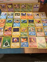 Full spread of 38 Pokémon cards laid flat on a surface showing varied characters and trainer cards.