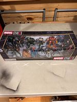 Full front view of the unopened Marvel Studios The First Ten Years Avengers Mega Figurine Set showing all 12 figures in display package.