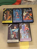 Five VHS tapes of Bubblegum Crisis lined up on a table showing front cover artwork and episode titles.