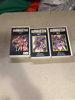 Three VHS tapes of Gunbuster anime, volumes 1, 2, and 3, displayed side-by-side on a table.