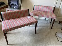 Photo showing two vintage bedroom benches with wooden legs and striped upholstery, positioned on a carpeted floor.
