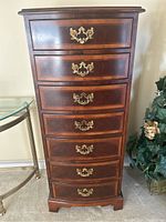 Front view of tall chest showing seven drawers and brass bail pulls