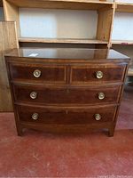Front view of dresser showing bow front profile and four drawers