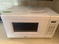 White Master Chef microwave with keypad and digital display, showing the front with door and keypad in focus.