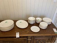 Wide view of all plates, bowls and platter arranged on wood table