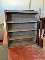 Front view of barn wood four tiered shelf showing four shelves, grayish weathered wood with knots and grain visible.
