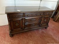 Front view of the dark wood sideboard showing carved details and overall condition