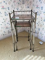 Front and side view of the pair of nesting tables showing metal tubular frame, bamboo lower shelf, and plexiglass top
