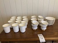 Full lot view showing drink vessels and saucers on wood surface