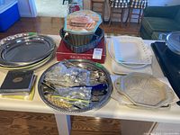 Wide view of all items on table showing trays, cupcake pans, utensils, and dishes for scale and context