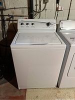 Front side view of Kenmore 500 washer showing white body and control panel with dials in basement setting.