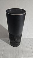 Front view of black Amazon Echo smart speaker showing cylindrical shape with mesh lower half.
