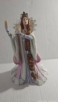 Full view of Lenox The Snow Queen figurine showing her standing in elaborate gown and crown with snowflake backdrop.
