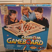 Original colorful product box showing children playing Carrom, brand name, and game details.