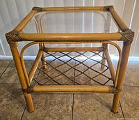 Front angled view showing the square rattan frame, glass top, wrapped corner details, and lattice lower shelf.