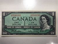 Front side of crisp 1954 Canadian $1 bank note showing full view with serial number.