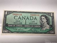 Front view of the 1954 Canadian one dollar banknote showing the Queen Elizabeth II portrait, serial number 0693116 in red, green background with black text and security engravings.
