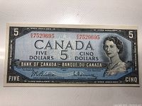 Front side of the 1954 Canadian $5 banknote showing Queen Elizabeth II portrait with serial number 7529695.