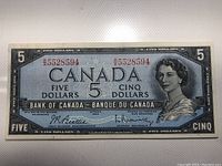 Front view of the 1954 Canadian $5 banknote showing Queen Elizabeth II and serial number R5528594.