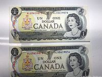 Top and bottom Canadian one-dollar banknotes from 1973 showing they are consecutive serial numbers ALU0619075 and ALU0619076.