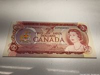 Front side of the 1974 Canadian 2 Dollar banknote showing Queen Elizabeth II portrait, denomination, bilingual text, and Canadian coat of arms holographic feature.
