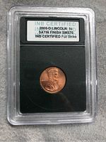 Certified coin in protective plastic holder showing label and 2005-D Lincoln cent obverse view.