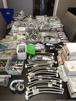 Overview of braided hoses, chrome P-traps, sealed fittings and boxed components spread across table