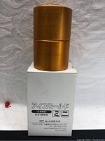 Front view of metallic gold mini ice mold on its box showing Japanese text and 'ICE MOLD' printed on the box