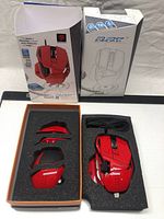 Opened box showing red Mad Catz R.A.T. 7 gaming mouse along with additional detachable parts in foam packaging.