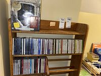 Shelf showing Lord of the Rings DVD set on top shelf and rows of music CDs below