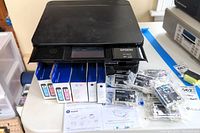 Printer, ink boxes and manual arranged on table