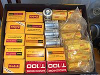 Overview of film boxes, loose wrapped rolls and metal canisters in tray