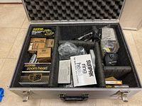 Foam-lined aluminum case containing Sunpak accessory boxes and miscellaneous items