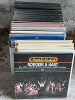 Stack of vinyl LP albums stored in a bin with the top album American Musicals: Rodgers & Hart visible
