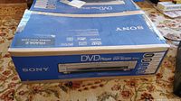 Sealed Sony DVD player DVP-NC85H box on carpeted floor