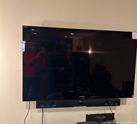 Sony Bravia large flat-screen TV mounted on wall with black bezel.
