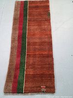 Full view of the runner-style rug showing overall color and design with vertical stripes and small geometric motif.