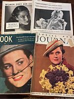 Photo showing several vintage magazines with early 20th century covers and ads.