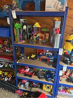 Full frontal view of shelving unit filled with toys and miscellaneous items to show scale and condition.