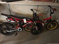 Image showing two boys bikes, one motocross style with number decals and another smaller red bike.