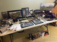 Full table view showing bat, framed prints, magazines, bobblehead boxes and other items