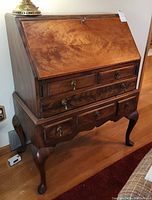 Front view showing drop‐front writing surface, two small upper drawers above two larger lower drawers with brass hardware