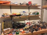 Overview of shelves with various tools including drills, saws, hardware organizer, painting tools, and insect killer spray.