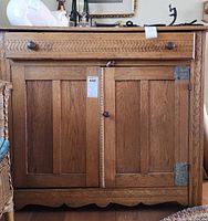 Front view of cabinet showing drawer, double doors, scalloped base apron