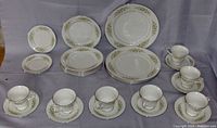 Full set arranged for photo showing all cups, saucers, and plates grouped by size